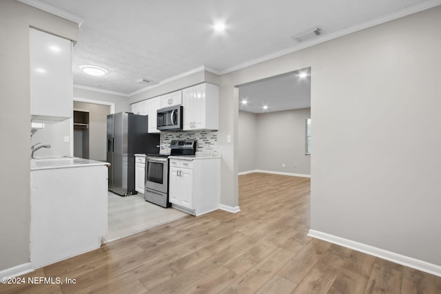 kitchen with white cabinetry, crown molding, stainless steel appliances, and light hardwood / wood-style floors