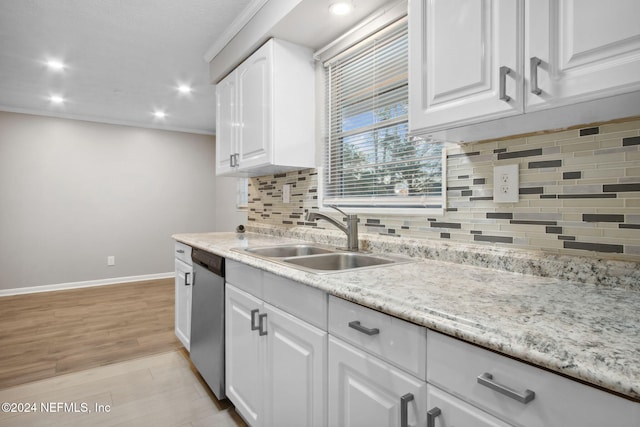 kitchen with backsplash, sink, stainless steel dishwasher, light wood-type flooring, and white cabinetry