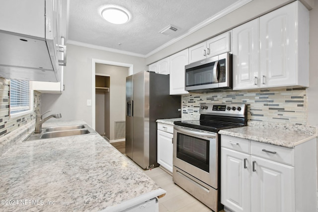 kitchen featuring backsplash, white cabinets, sink, ornamental molding, and appliances with stainless steel finishes