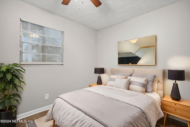 bedroom with ceiling fan, a textured ceiling, and hardwood / wood-style flooring