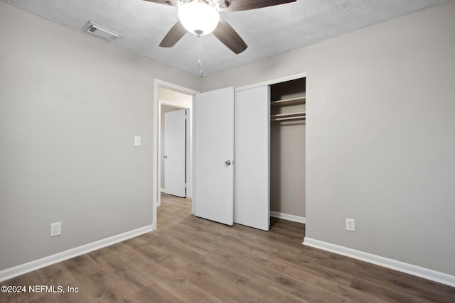 unfurnished bedroom with a closet, ceiling fan, hardwood / wood-style floors, and a textured ceiling