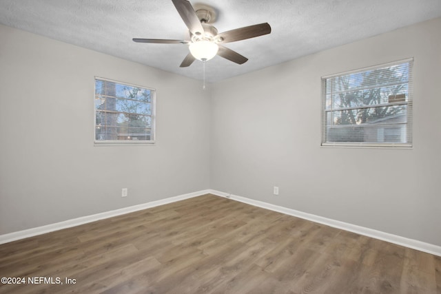 spare room with hardwood / wood-style floors, a textured ceiling, and a healthy amount of sunlight