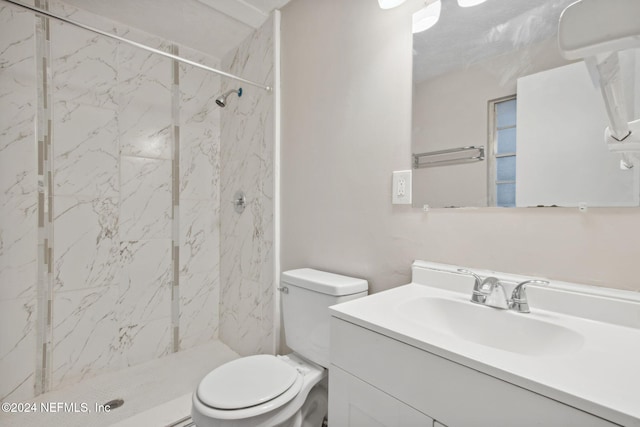 bathroom featuring tiled shower, vanity, and toilet