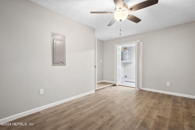 empty room with hardwood / wood-style flooring, ceiling fan, a textured ceiling, and electric panel