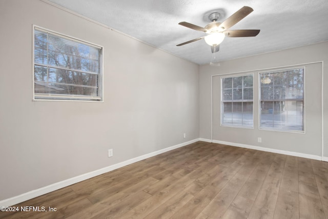 empty room with hardwood / wood-style floors, ceiling fan, and a textured ceiling