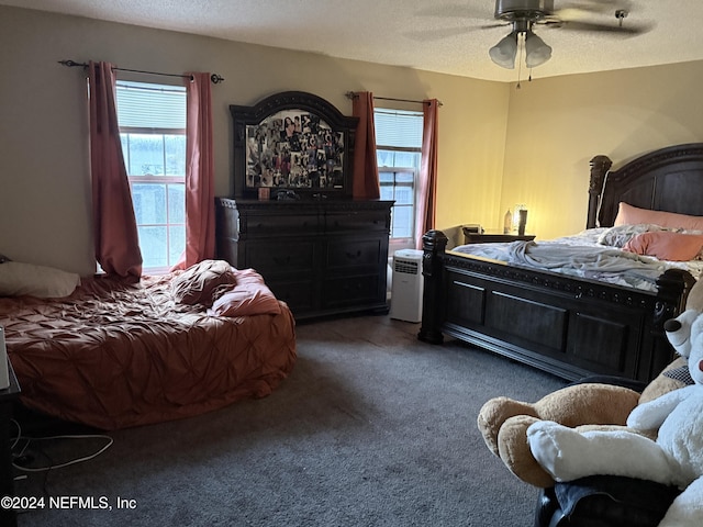 carpeted bedroom with ceiling fan and a textured ceiling