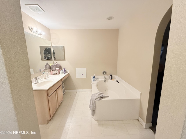 bathroom featuring tile patterned floors, a tub to relax in, and vanity