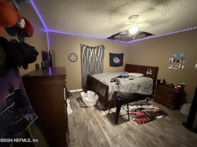 bedroom featuring ceiling fan, a textured ceiling, and hardwood / wood-style flooring