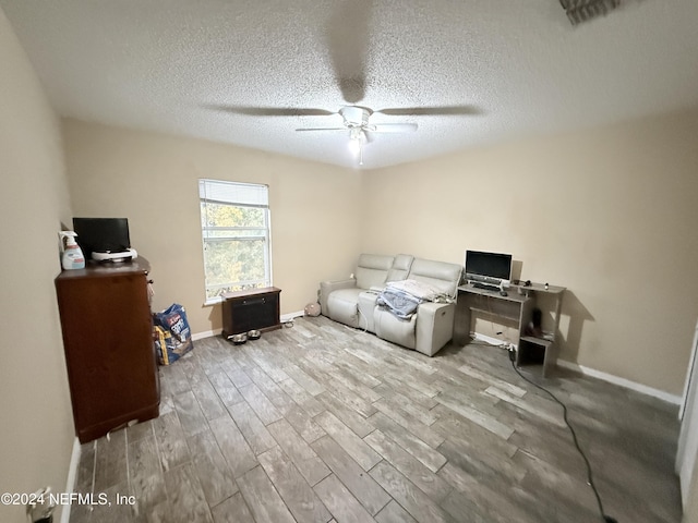 office with a textured ceiling, light hardwood / wood-style floors, and ceiling fan