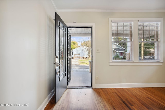 entrance foyer with hardwood / wood-style floors and ornamental molding