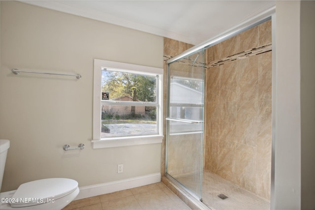 bathroom with tile patterned flooring, toilet, and an enclosed shower