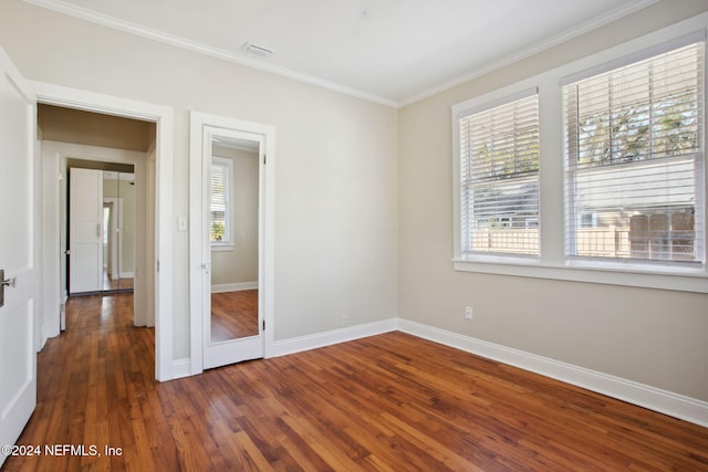 unfurnished bedroom with dark hardwood / wood-style flooring and ornamental molding