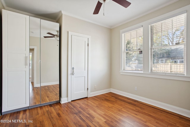 unfurnished bedroom with dark hardwood / wood-style floors, ceiling fan, and ornamental molding