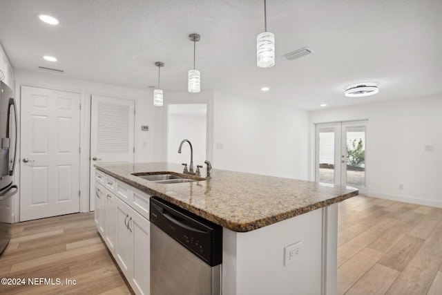 kitchen featuring pendant lighting, white cabinets, a center island with sink, sink, and appliances with stainless steel finishes