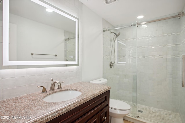 bathroom featuring tasteful backsplash, an enclosed shower, vanity, tile walls, and toilet