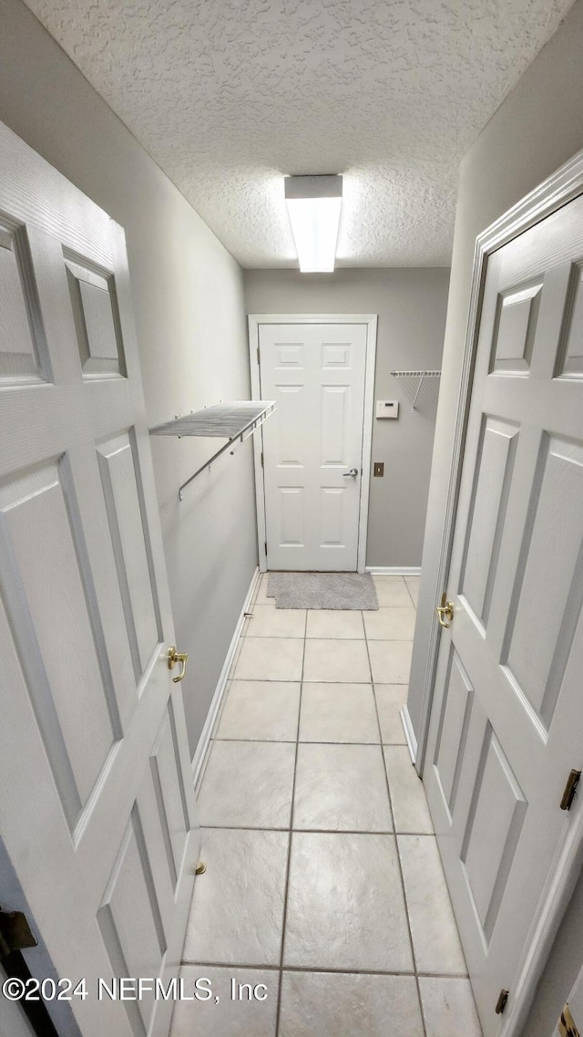 interior space featuring a textured ceiling and light tile patterned flooring