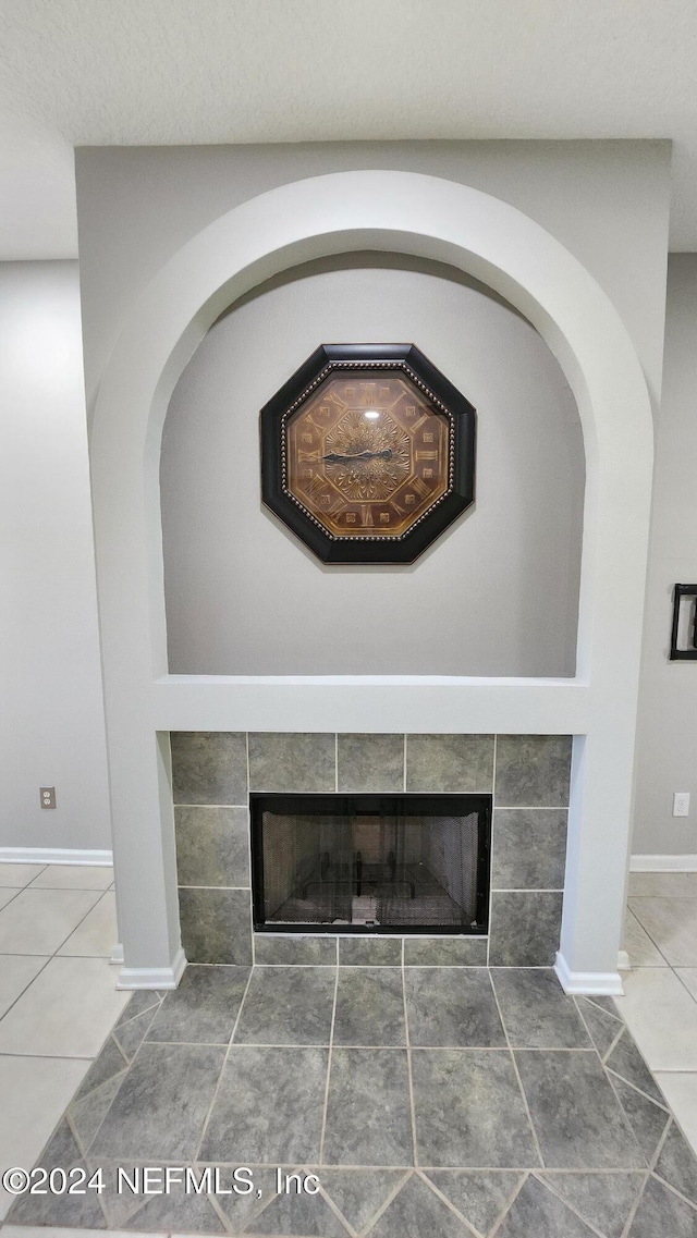 details featuring a textured ceiling and a tiled fireplace