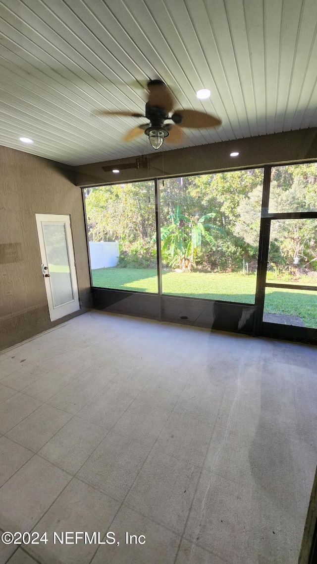 unfurnished sunroom with ceiling fan and a healthy amount of sunlight