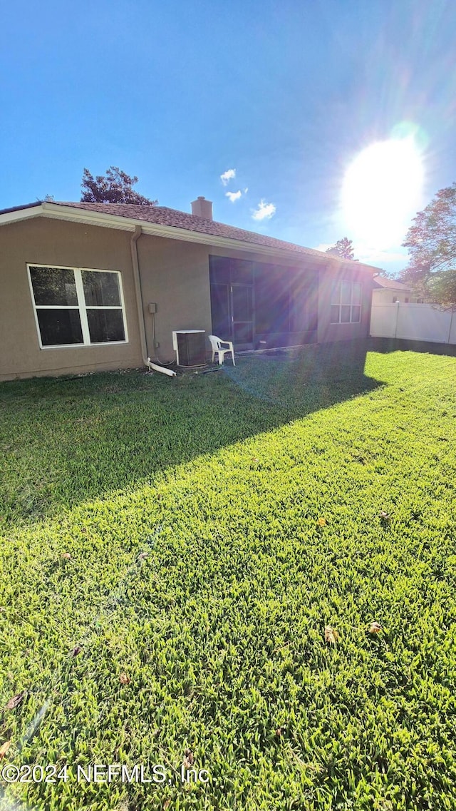 back of house featuring a lawn