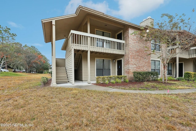 exterior space featuring a front yard and a balcony