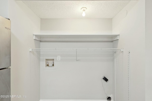 laundry room with hookup for a washing machine and a textured ceiling