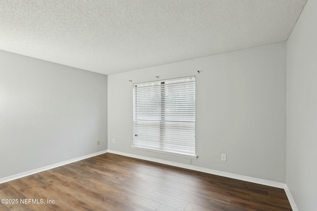 unfurnished room featuring dark wood-type flooring, a wealth of natural light, and a textured ceiling