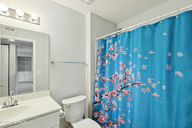 bathroom with vanity, toilet, a shower with shower curtain, and a textured ceiling