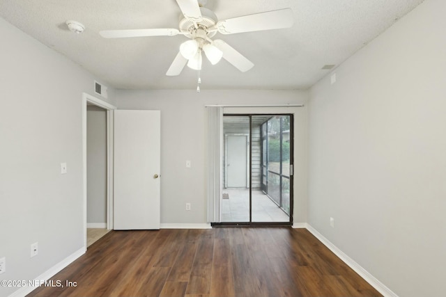 unfurnished room with ceiling fan, dark hardwood / wood-style floors, and a textured ceiling