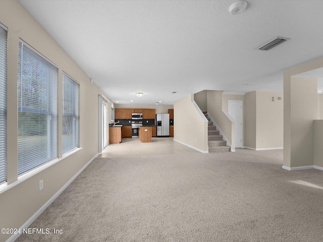 unfurnished living room featuring light carpet