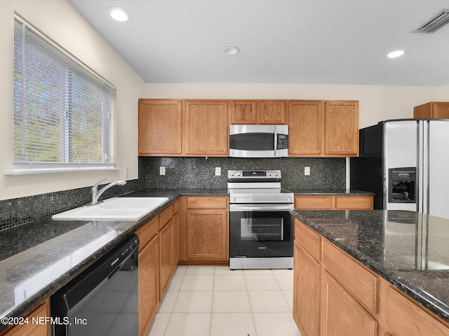 kitchen with sink, light tile patterned floors, stainless steel appliances, and tasteful backsplash