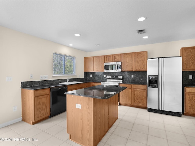 kitchen featuring tasteful backsplash, sink, a kitchen island, and appliances with stainless steel finishes