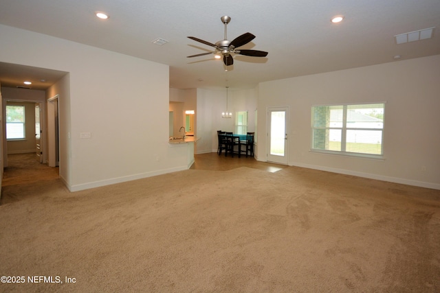 unfurnished living room featuring ceiling fan and carpet