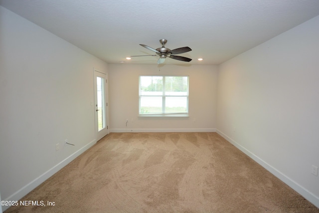 spare room with light carpet and ceiling fan