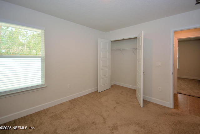 unfurnished bedroom featuring a closet and light carpet