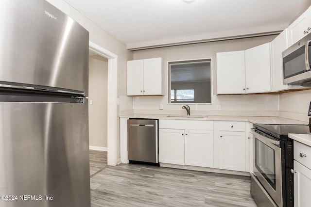 kitchen featuring white cabinets, appliances with stainless steel finishes, light hardwood / wood-style floors, and sink