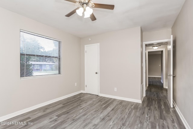 unfurnished bedroom with a closet, ceiling fan, and dark wood-type flooring