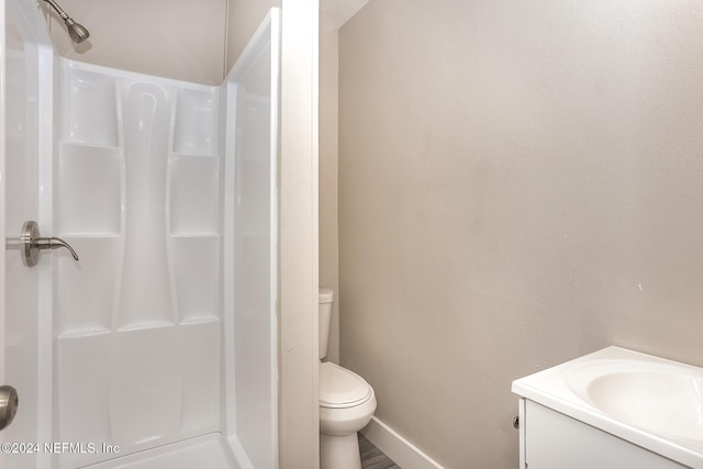 bathroom featuring a shower, vanity, and toilet