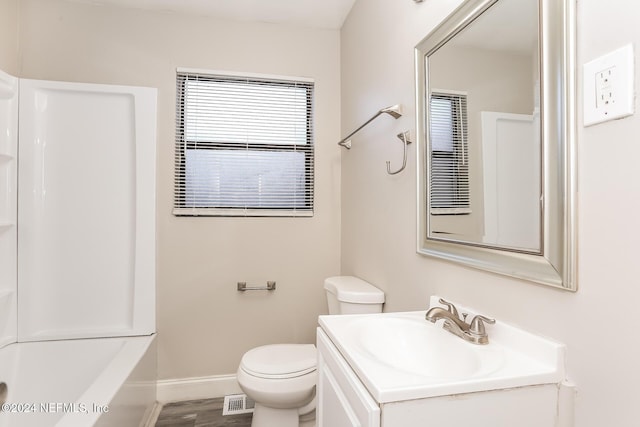 full bathroom with washtub / shower combination, hardwood / wood-style floors, vanity, and toilet