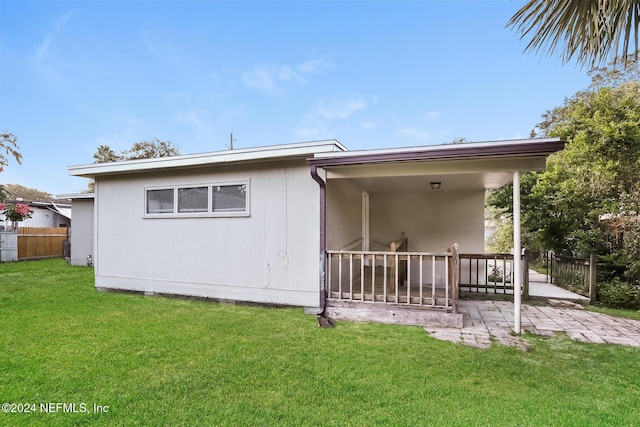 rear view of house featuring a yard and a patio