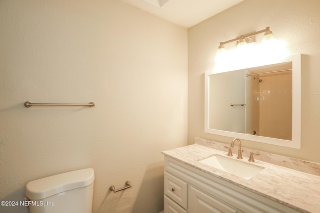 bathroom with vanity, toilet, and walk in shower