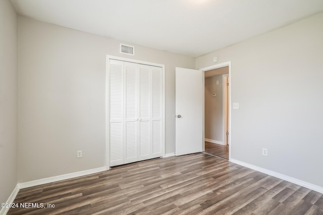 unfurnished bedroom featuring hardwood / wood-style floors and a closet