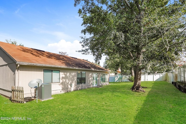 exterior space featuring central air condition unit and a lawn