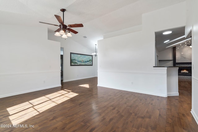 unfurnished living room featuring a textured ceiling, ceiling fan with notable chandelier, dark hardwood / wood-style floors, and lofted ceiling