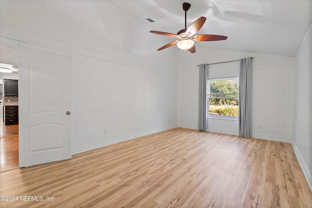 empty room featuring ceiling fan, light hardwood / wood-style floors, and lofted ceiling