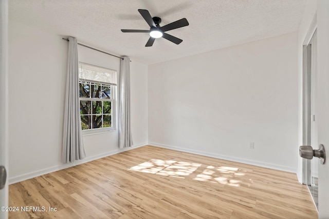 spare room featuring ceiling fan, light hardwood / wood-style flooring, and a textured ceiling