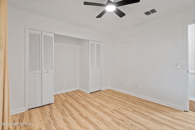 unfurnished bedroom with ceiling fan, light wood-type flooring, a textured ceiling, and a closet