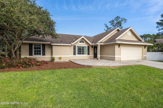 ranch-style home featuring a garage and a front lawn