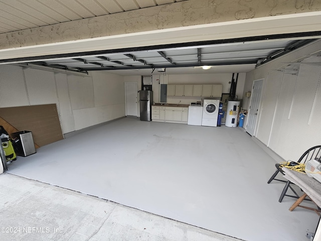 garage with stainless steel fridge, separate washer and dryer, electric water heater, and electric panel