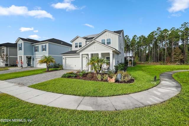 view of front of property featuring solar panels, a garage, and a front yard