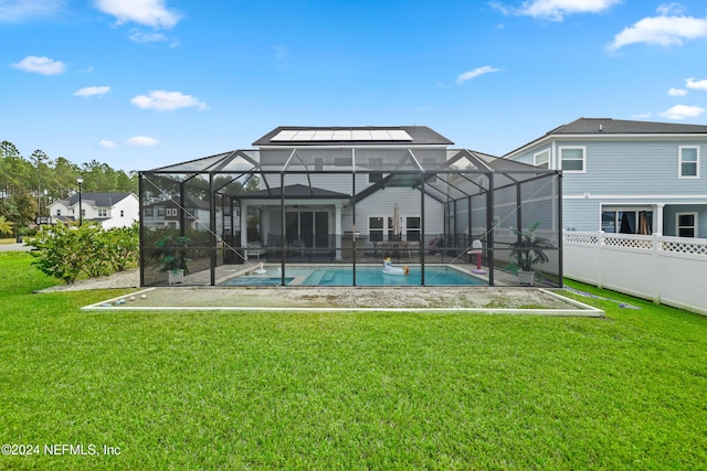 back of house with a yard and glass enclosure